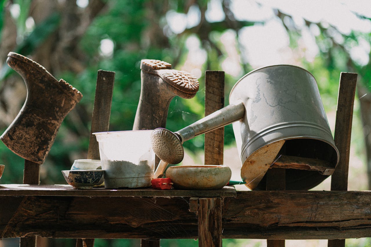 services-bg A collection of rustic gardening tools arranged on a wooden shelf, creating a serene outdoor scene.